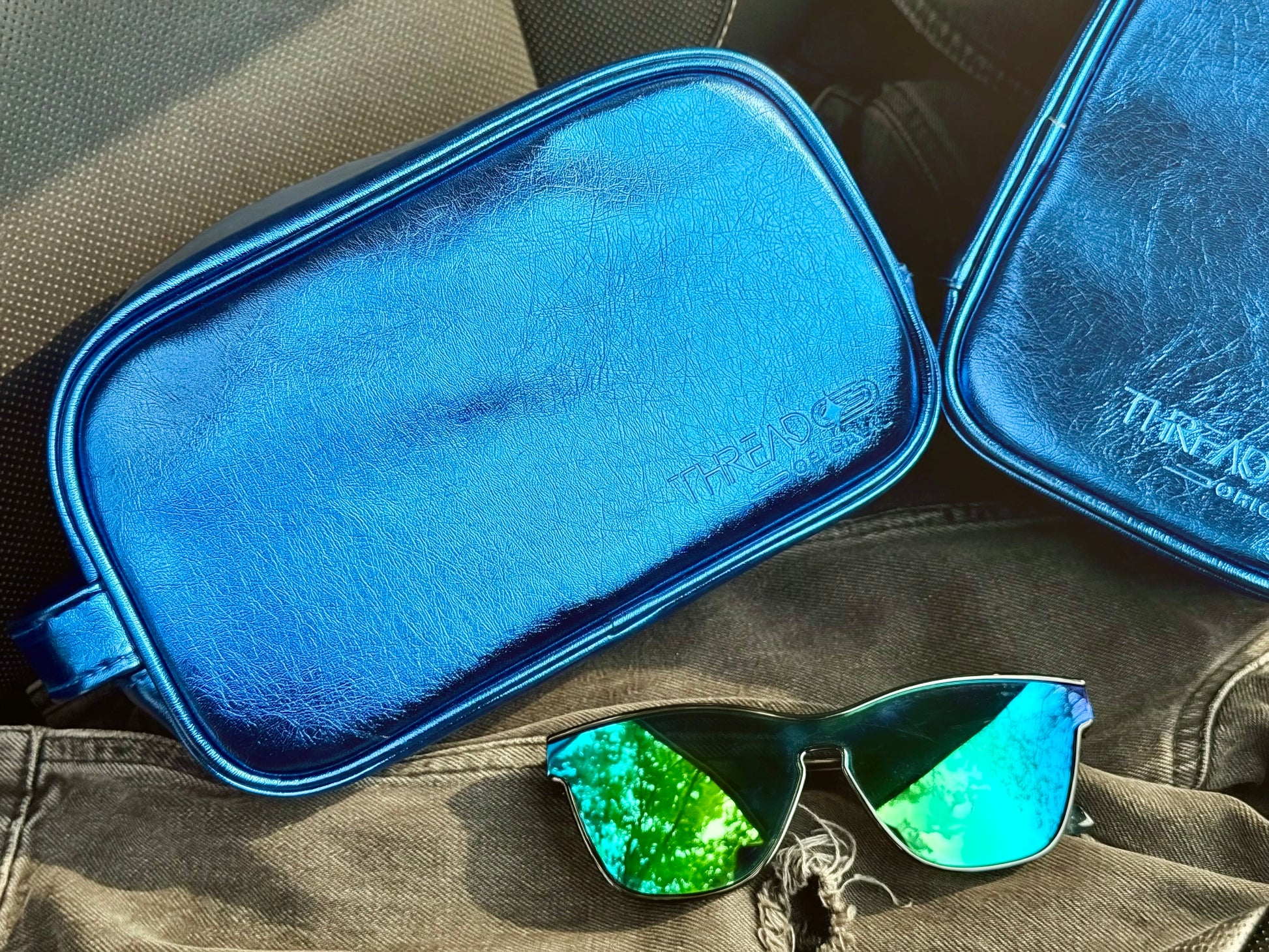 Ocean Aurora LED travel makeup organizer displayed on a car seat with mirrored sunglasses.