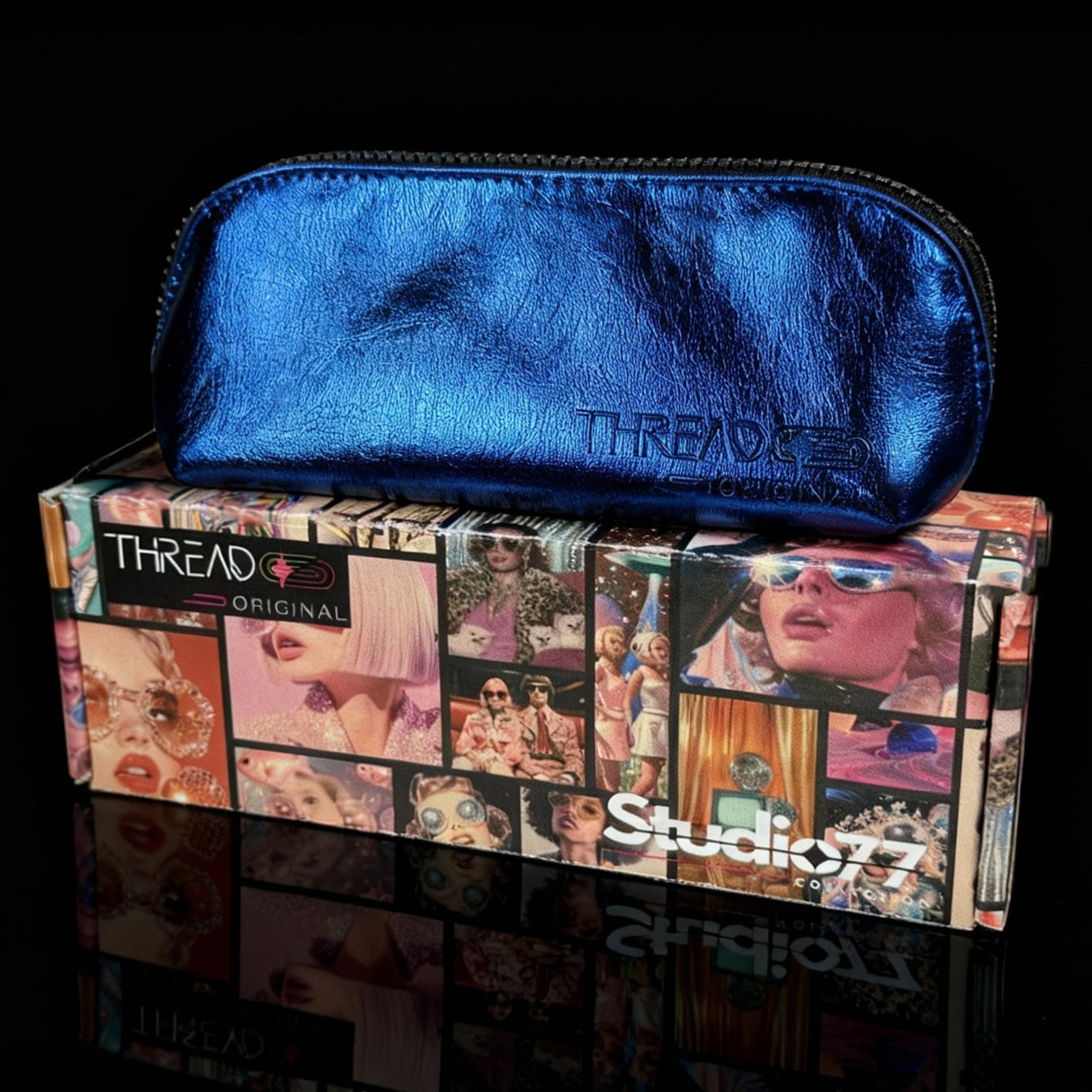 Ocean blue metallic compact makeup bag on collectible Studio 77 gift box. Slim vegan leather cosmetic pouch with wipeable insulated lining by Thread Original.