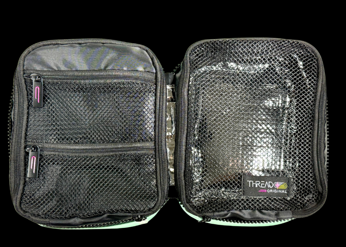 Multi-compartment makeup organizer with mesh zip pockets and wipeable insulated interior by Thread Original.